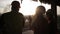 Foreman talks to women inspectors at the site in the light of the setting sun. Silhouettes of construction workers in