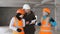The foreman and two women in construction helmets in the winter on the construction site to inspect the status of the