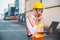 Foreman woman worker working checking at Container cargo harbor holding laptop computer and radio walkie-talkie to loading