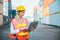 Foreman woman worker working checking at Container cargo harbor holding laptop computer to loading containers. Dock female staff