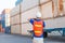 Foreman worker in hard hat and safety vest talks on two-way radio control loading containers box from cargo