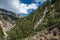 Forest in ArgentiÃ¨re with glacier creek and snowy mountains