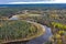 Forest in autumn colors. Colored trees and a meandering blue river. Red, yellow, orange, green deciduous trees in fall.