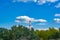 Forest and blue sky with clouds and factory chimney