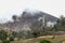 A forest burned by gases and sulfur around the Volcanic cone in the danger zone in the middle of a green and cloudy landscape in