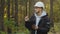 Forest evaluation and management. Millennial Indian Forestry engineer in hardhat with tablet in woods. Forester foreman