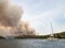 Forest fire in Croatia, summer natural disaster close to national park Krka, Sibenik region, boats and yachts escaping Skradin to