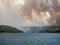 Forest fire in Croatia, summer natural disaster close to national park Krka, Sibenik region, boats and yachts escaping Skradin to