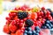 Forest fruits like a blueberries, raspberries, strawberries, red currants on a market. On a white tablecloth. Harvesting, agricult