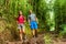 Forest hike hikers hiking in rainforest trail in Hawaii. Interracial couple walking in travel adventure. Asian woman