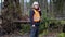 Forest inspector with smartphone near tree in destroyed forest