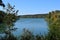 Forest lake in the autumn afternoon. Calm water with reflection of trees