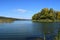 Forest lake in the autumn afternoon. Calm water with reflection of trees