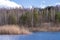 Forest lake in early spring with blue water and cloudy picturesque sky. Background