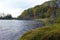 Forest lake with grassy shores in autumn