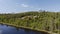 Forest lake, hill and forest behind it long aerial view