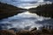 Forest lake with reflected clouds, nature background with copy space