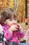 In the forest a little girl eats red apple