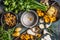 Forest Mushrooms cooking preparation on rustic kitchen table with empty cooking pot and vegetables, top view. Autumn cooking