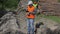 Forest officer near logs with cell phone