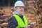 Forest Officer with tablet PC near piles of logs