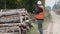 Forest officer using tablet PC near logs in the woods