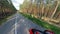 Forest road and a person driving the motorbike. Motorcycle on a road.