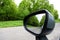 Forest road reflection, rearview car driving mirror view green