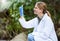 Forest, sample and woman scientist test water for research or inspection of the ecosystem and environment study. Science