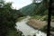 Forest side river flowing by the side of mountain