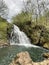 Forest in spring with a large waterfall pouring its water into a pond, rocks in the foreground, Xorroxin water fall, Erratzu,
