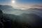 Forest with sun rays. Morning with sun. Cold misty foggy morning in a fall valley of Bohemian Switzerland park. Hills with fog, la