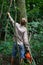 A forester cleans the forest from shrubs, forest maintenance, a guy with a chainsaw selects trees for cutting