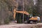 Forestry excavator mulcher doing roadside clearing with mulching machine.