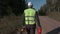 Forestry worker walking on the road with chainsaw