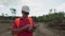 Forestry worker in white helmet with digital tablet checking trees