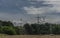 Forests and blue sky wih clouds and windy power plants and electric poles