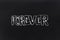 Forever text written on black chalkboard