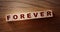 FOREVER word on wooden cubes on wooden Floor. Eternal love or trustworthy business longterm relationship concept