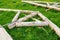 forged steel stripe connection of wooden log beams for roof support girder framework laid on green grass at summer day