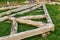 forged steel stripe connection of wooden log beams for roof support girder framework laid on green grass at summer day