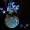 Forget-me-nots flowers in vase on the dark table