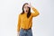 Forget remember. Shocked woman slap forehead and gasping startled at camera, standing in casual yellow sweater and jeans