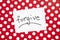 Forgive - word on white real paper with red and dots background, religion and relationship