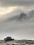 Forgotten black cowboy hat on rocky cliff above misty landscape