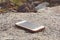Forgotten white smartphone on a rock