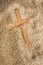 Forgotten Wooden Cross on Sand Texture Background