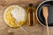 Fork in bowl with mix of eggs, flour and corn, vegetable oil, food turner in frying pan on table. Top view