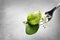 Fork with delicious Brussels sprouts salad on grey background, closeup.