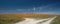 Fork in a desert dirt road through California Golden Orange Poppies under blue sky in the high desert of southern California